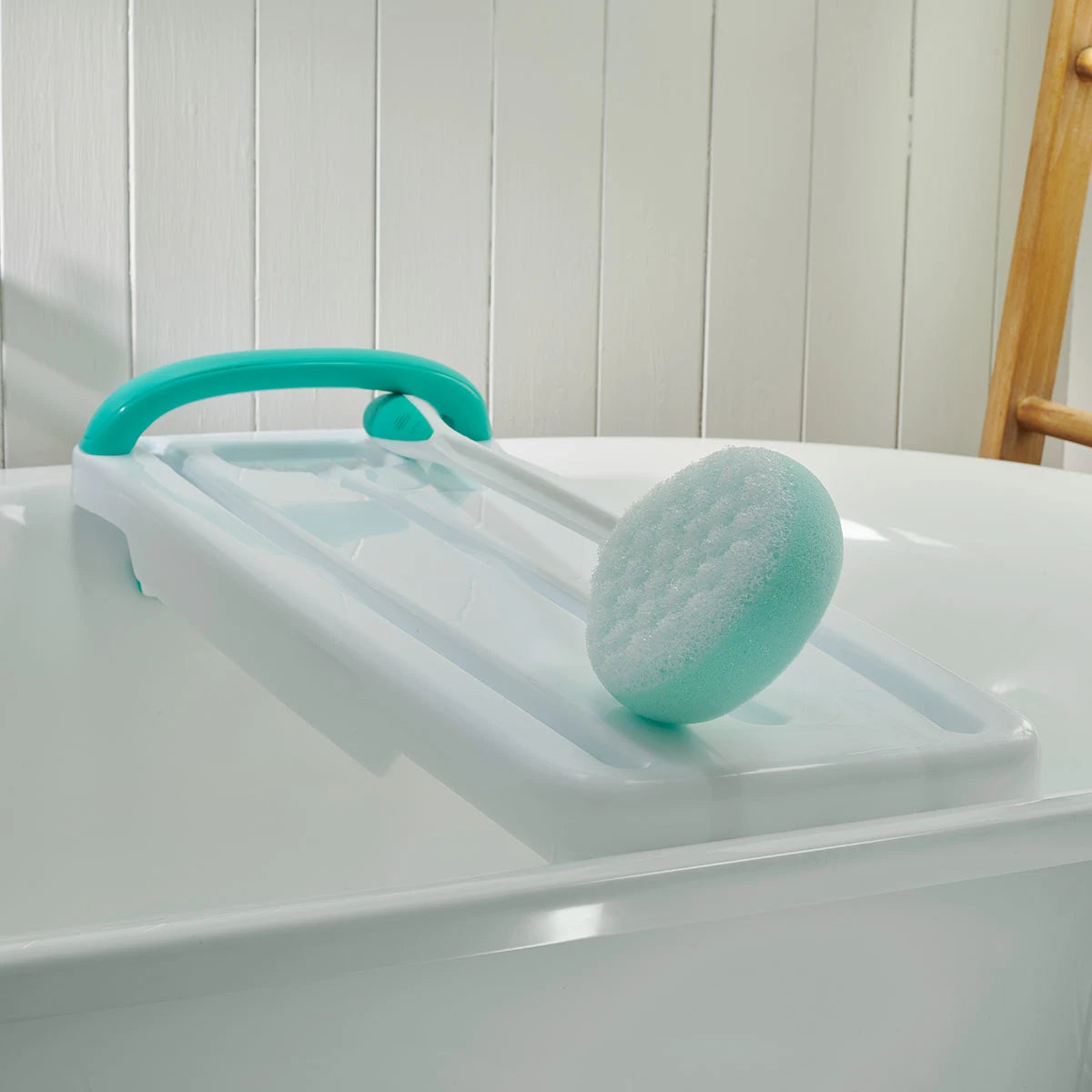 Turquoise bath sponge attachment on a bathtub table