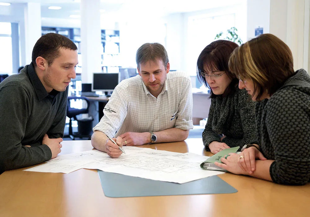 Four people working together at a table with Skyframe installation documents.