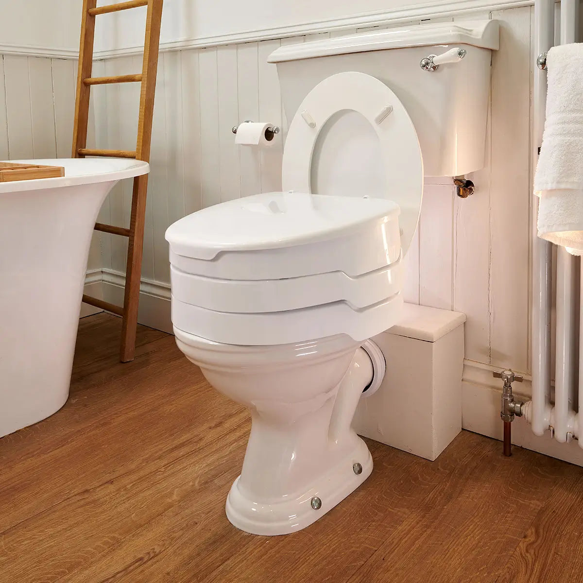 White Ezy fit Raise Toilet Seat 6 Inches in a bathroom with wooden floor.
