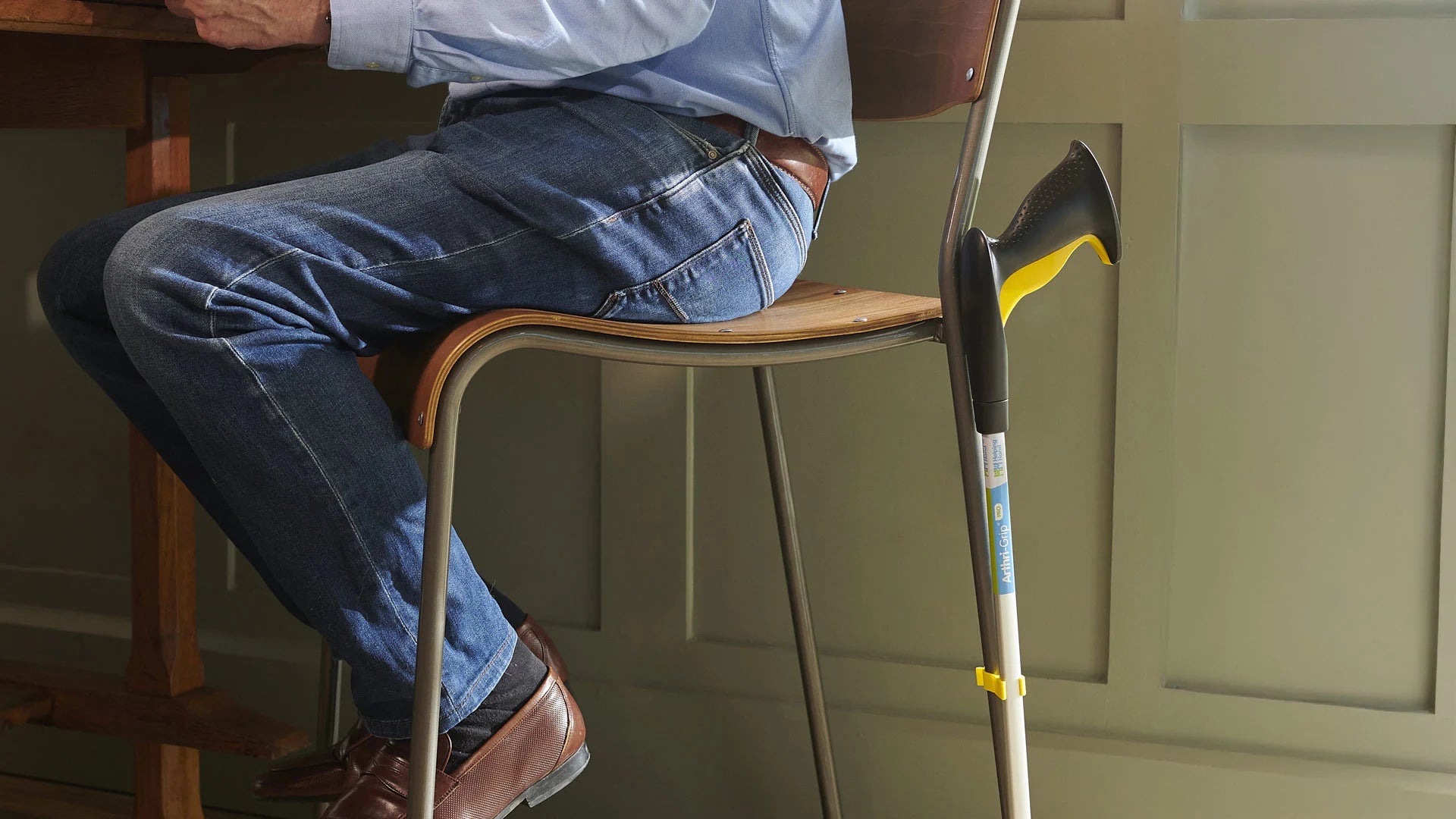 Person sitting on a chair with a anthrigrip reacher