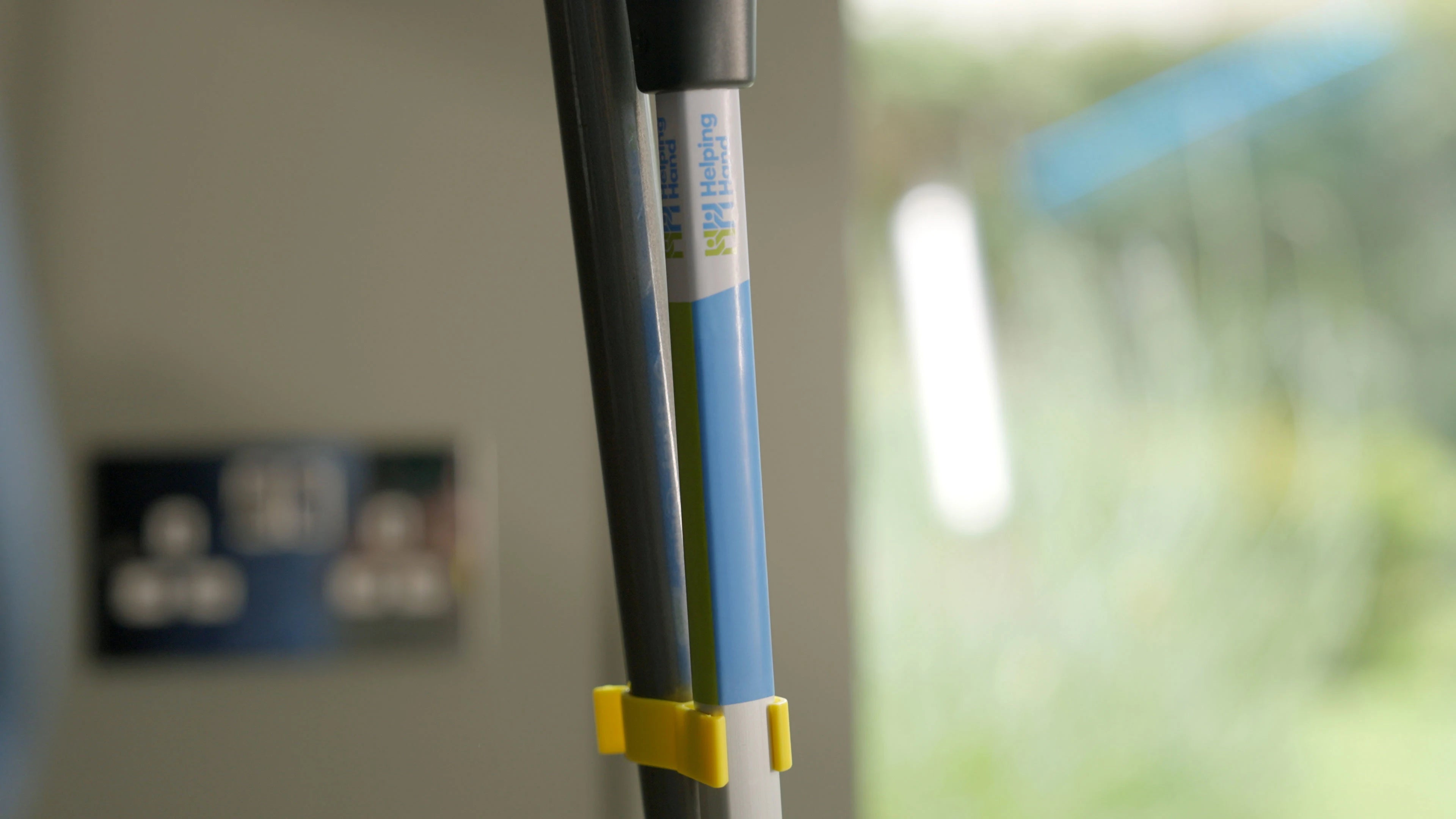 Tong handle with a yellow clip against a blurred indoor background