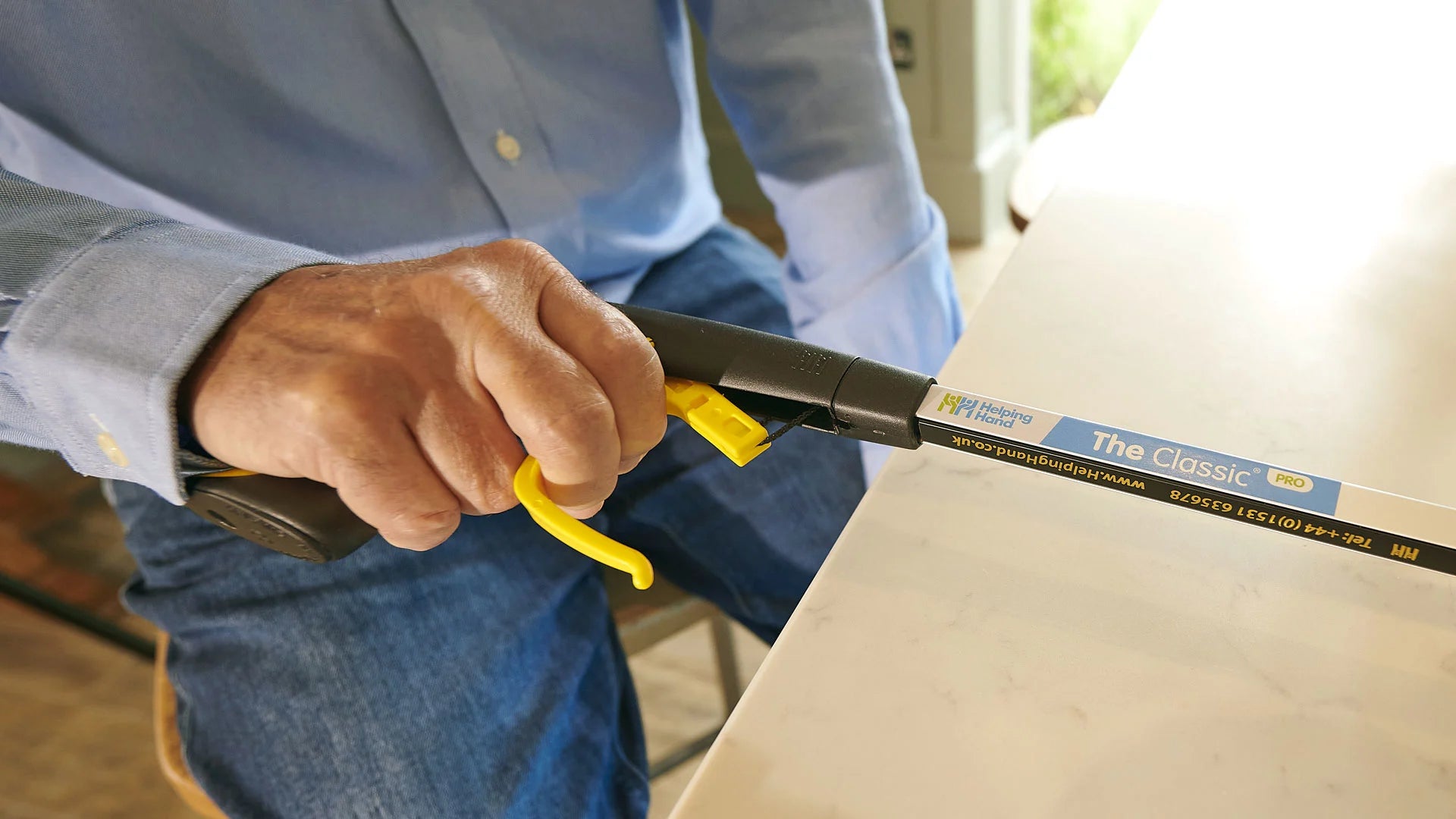 Person using a tool labelled 'The classic' on a piece of furniture.