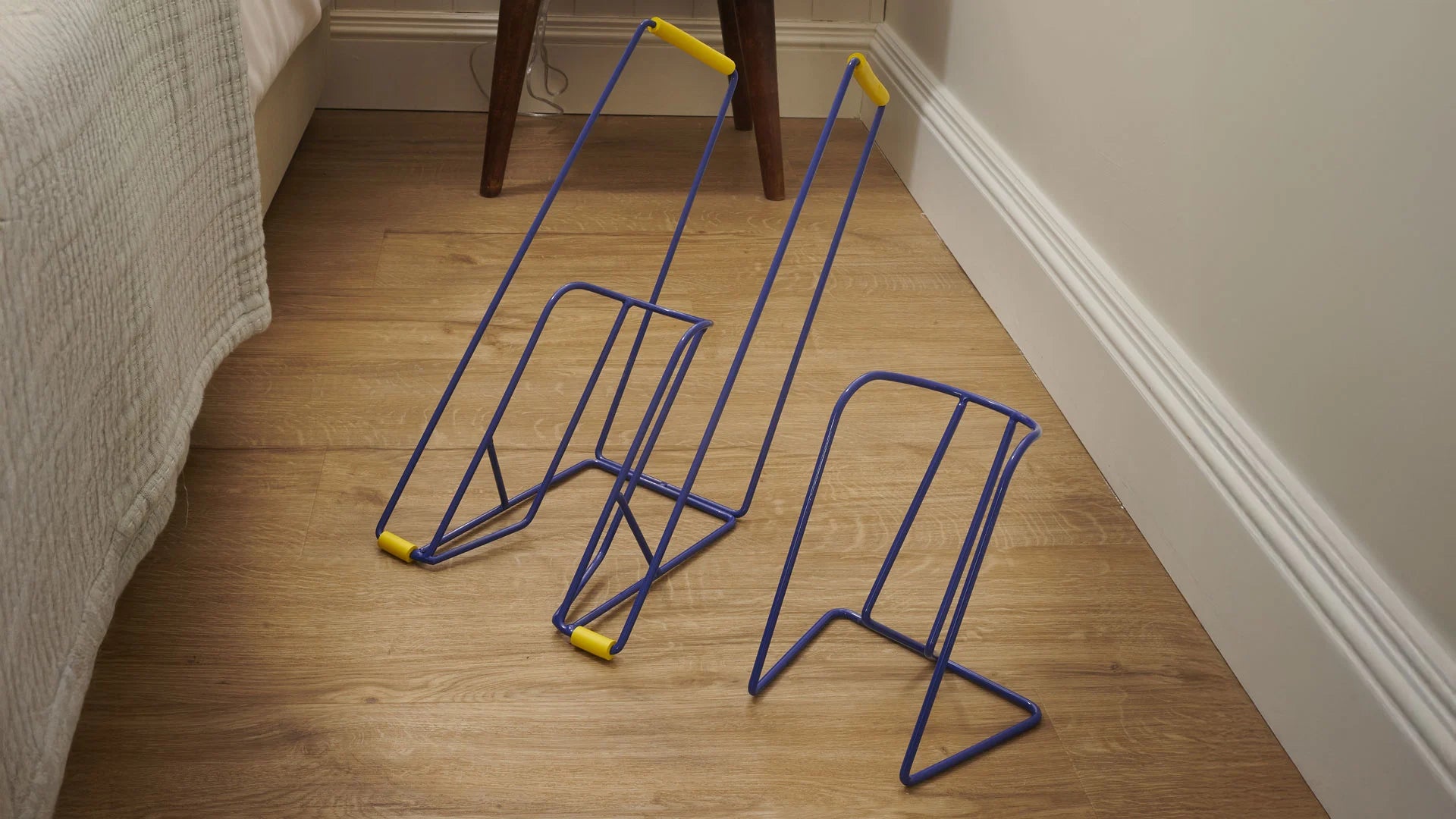 Two blue sock aids on a wooden floor