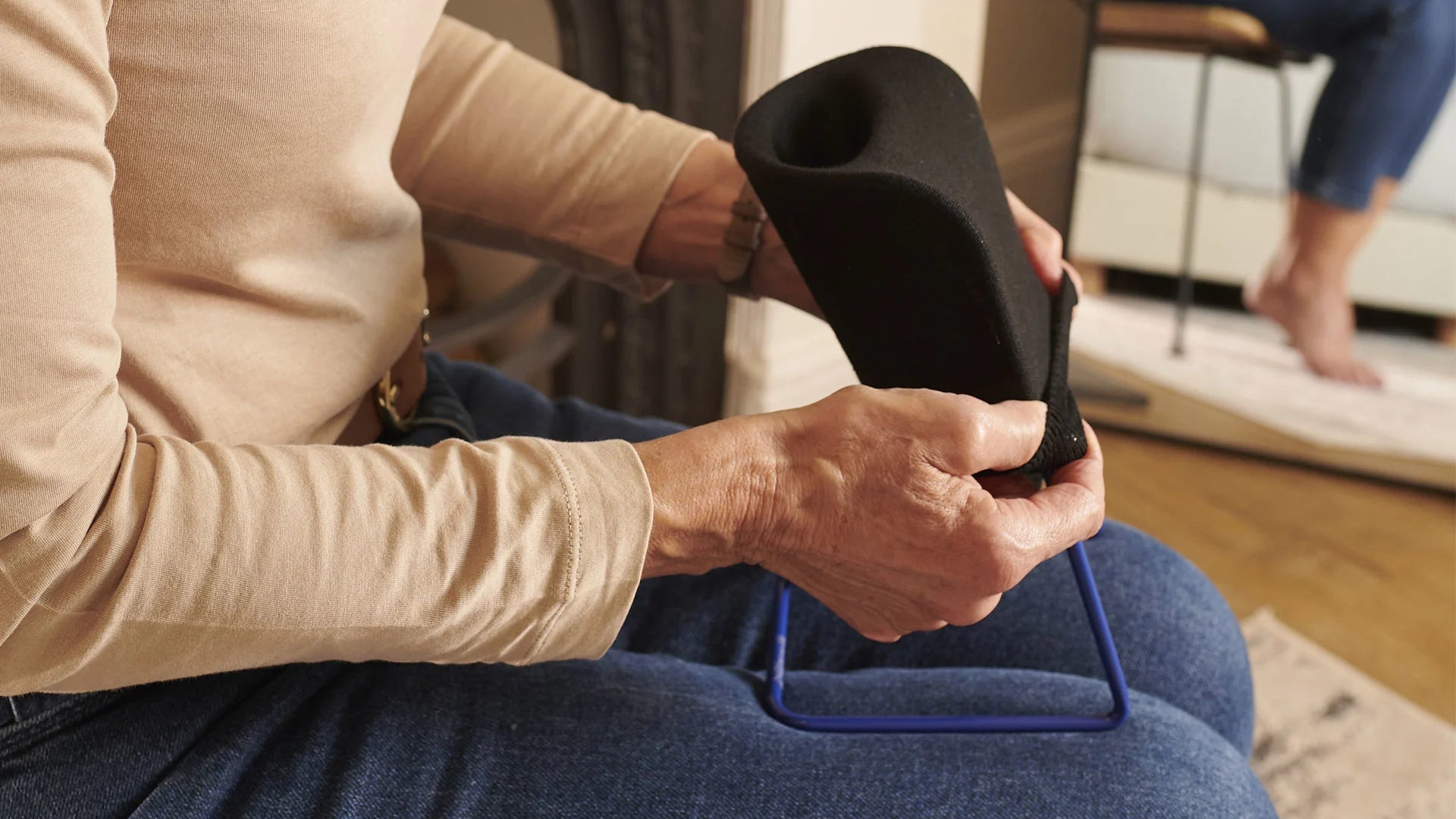 A person putting a sock on a sock aid