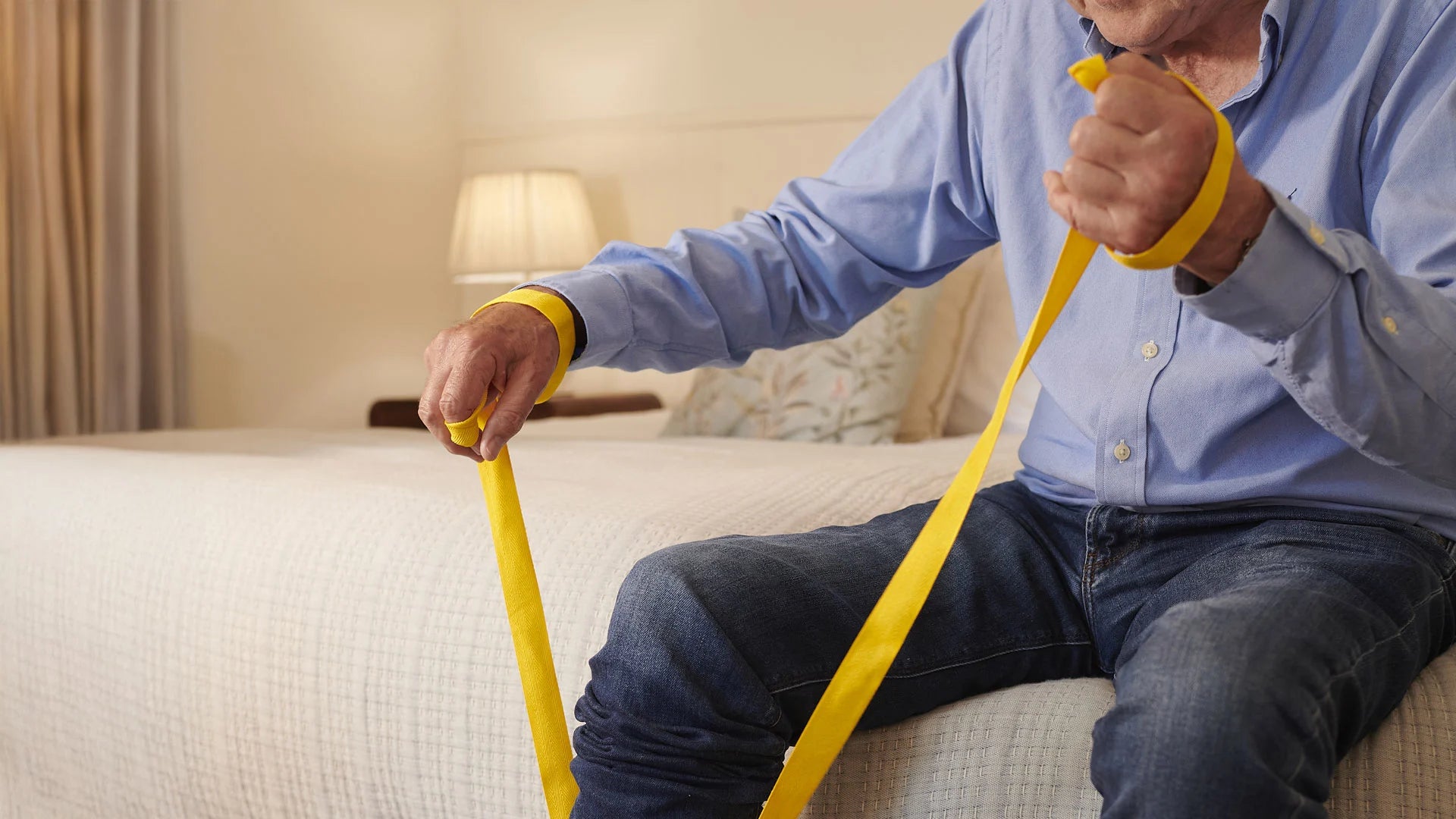 Man holding yellow straps to the foxy sock aid