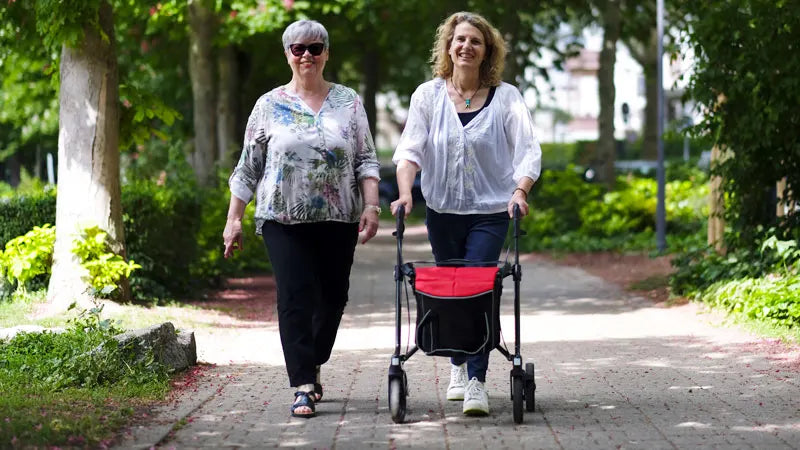 Person walking with Gemino 30 Carbon mobility walker outside with friend.