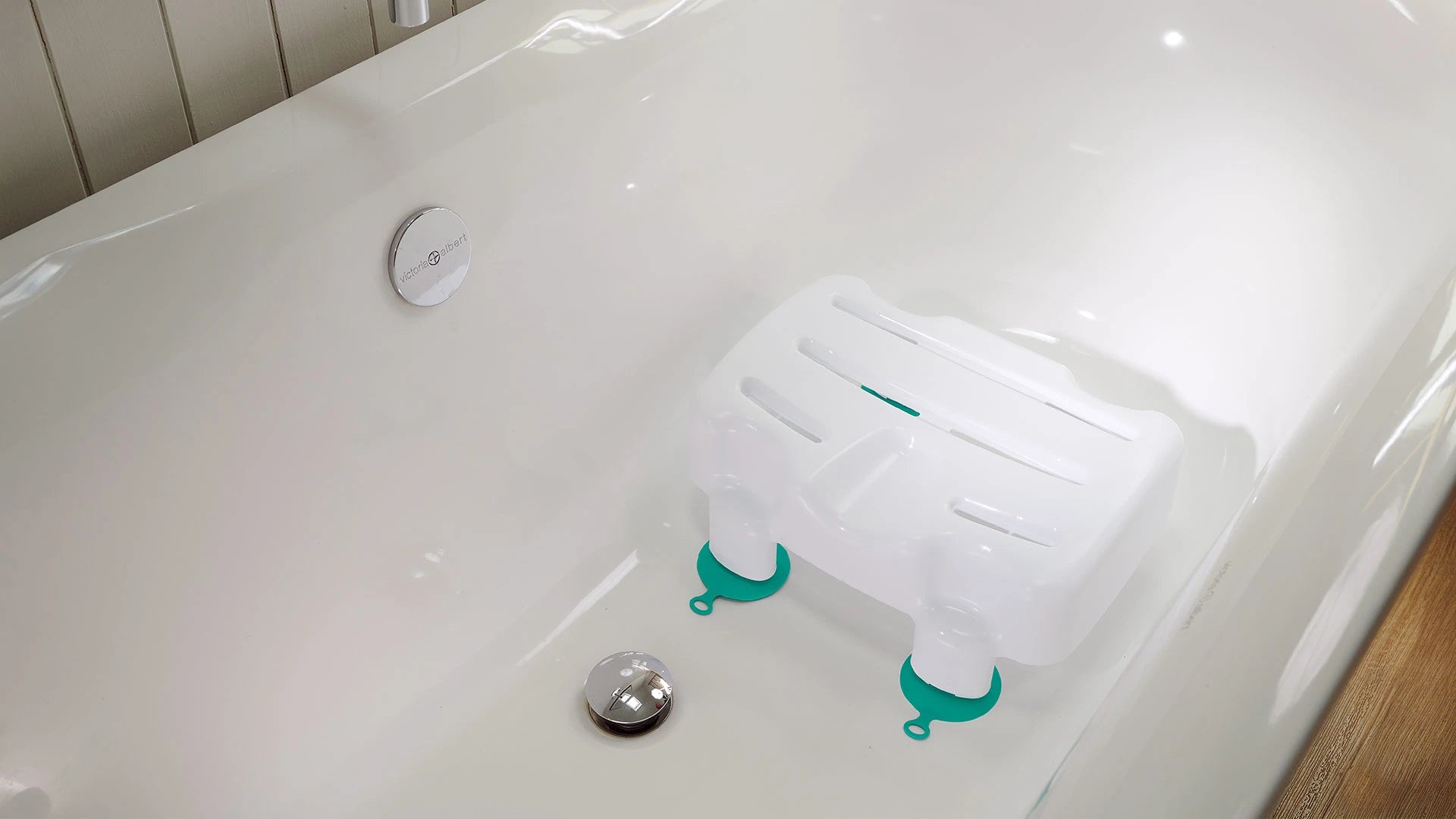 Bath tub with a shower seat and anti-slip mats on a wooden floor.