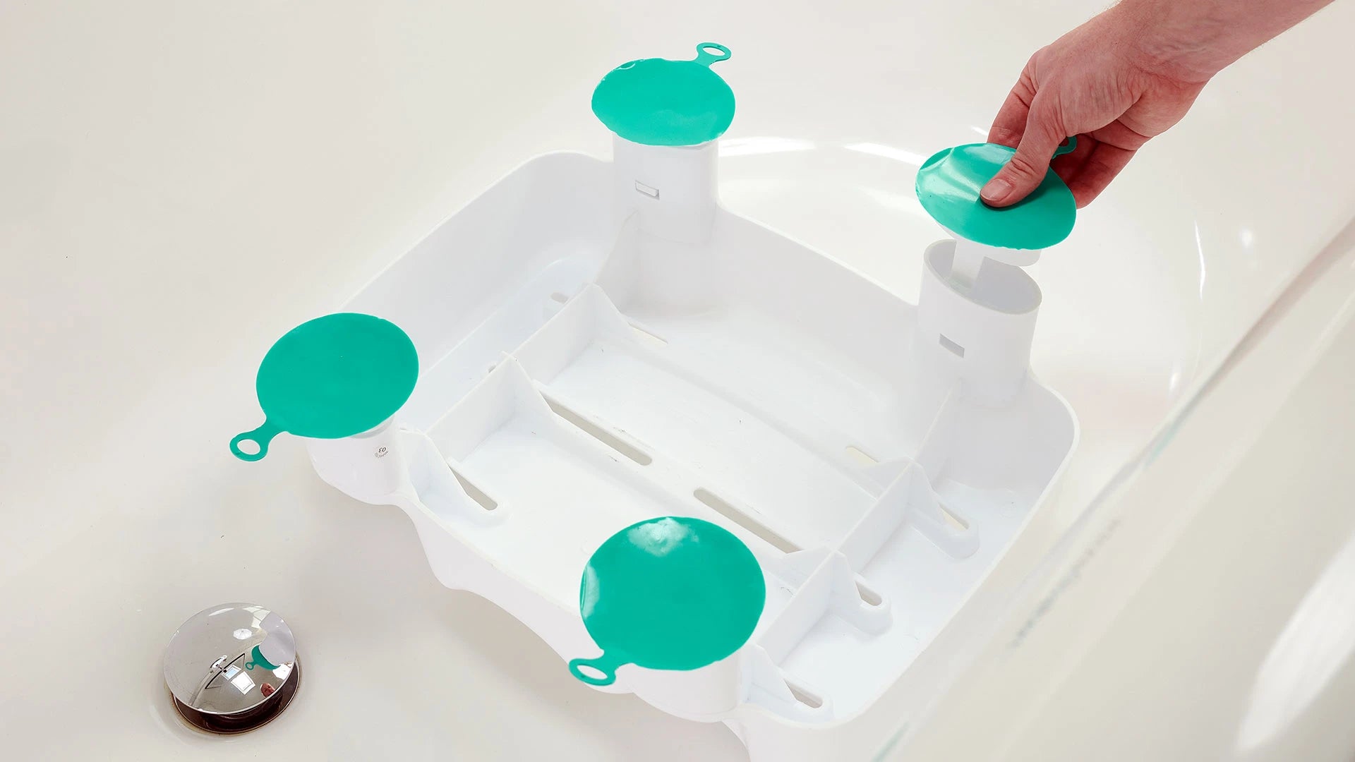 White bath seat with teal suction cups on a white background