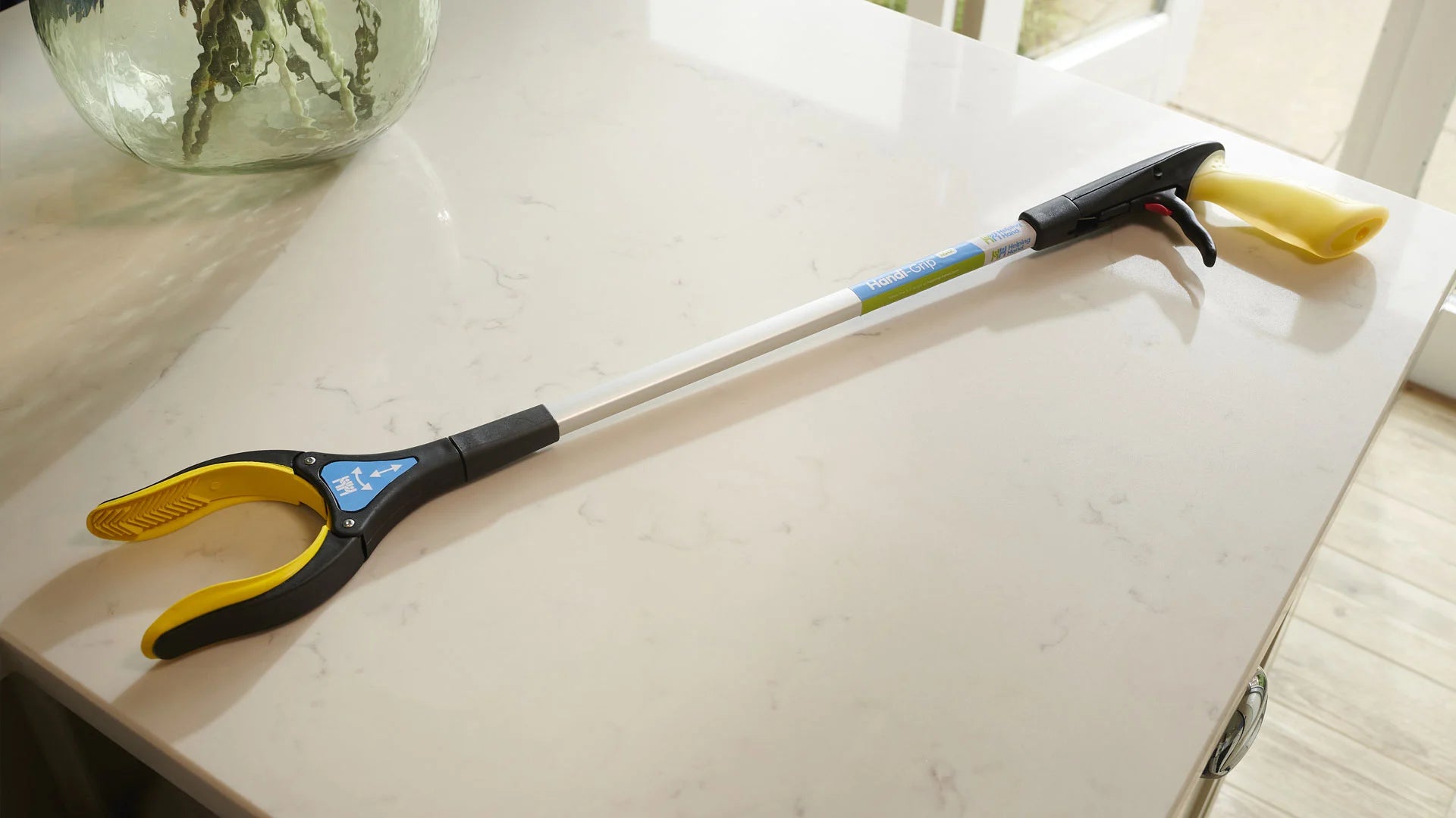 The maxi grip with yellow and black handle on a white surface