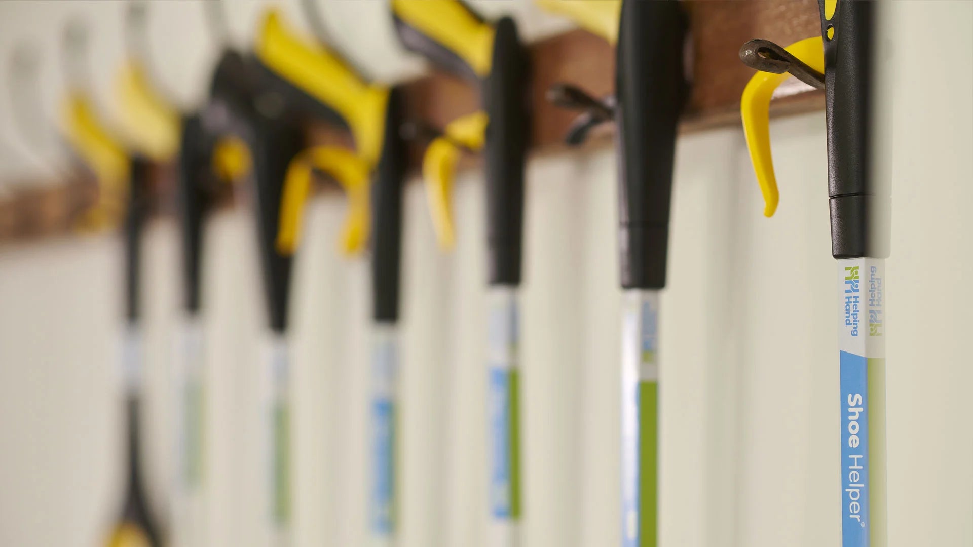 Row of reachers with visible brand labels on a wooden rack.