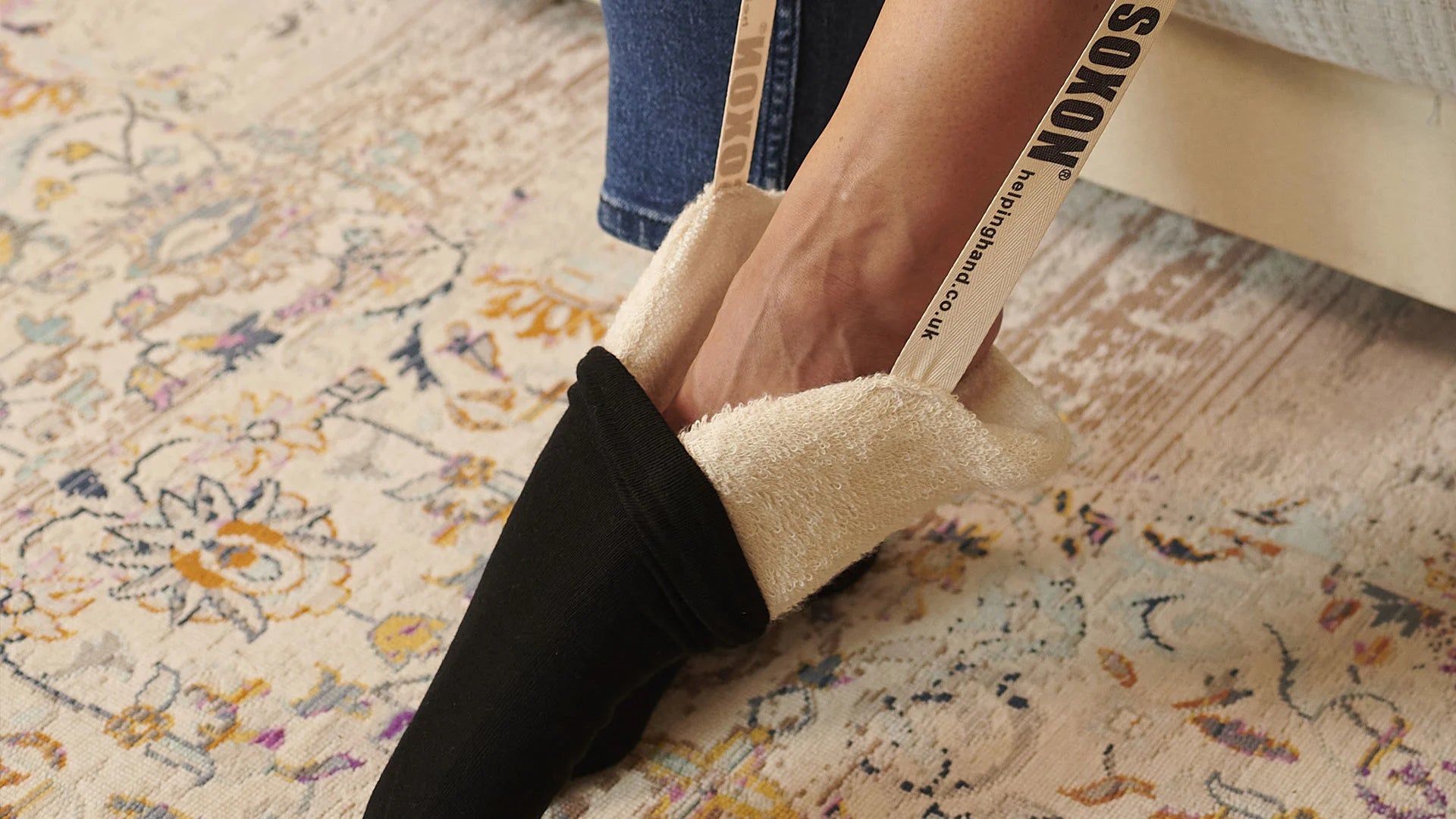 A person using a sock aid to put on socks