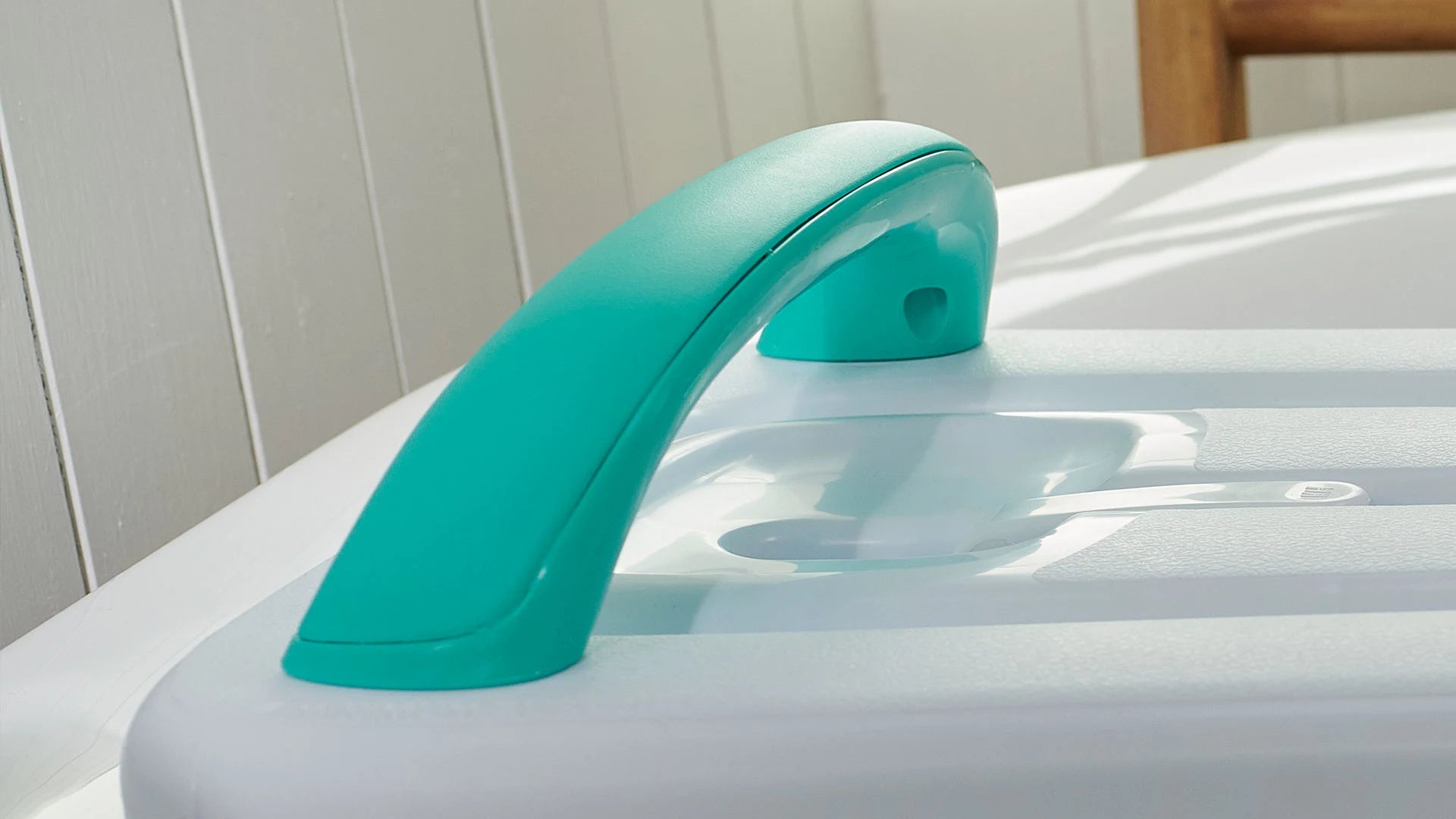 Turquoise handle on a white surface with a neutral background