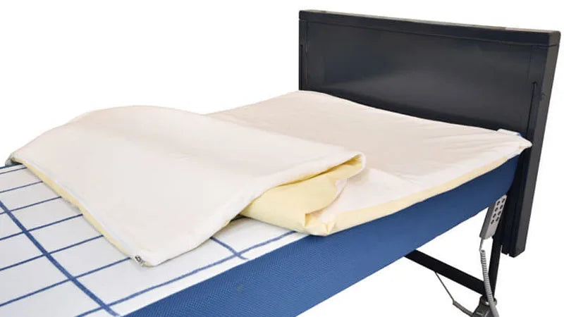 Bed with a white mattress topper on a white background