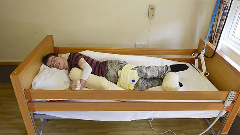 Person lying in a symmslyde postural care bed.