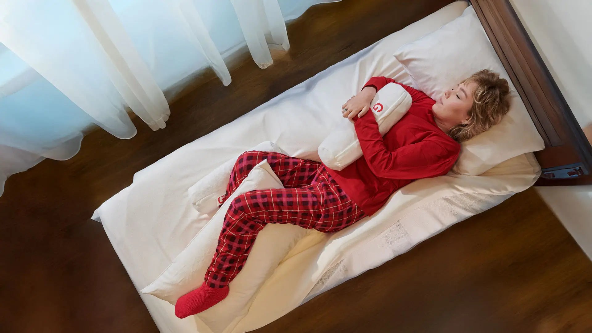 Woman lying on a bed with a  SymmetriSleep positioning system.