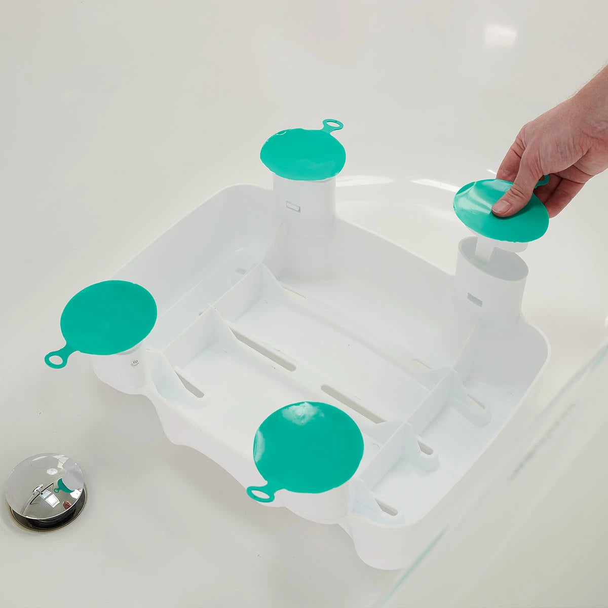 Bath tub with a white bath seat and green suction cups on a white background