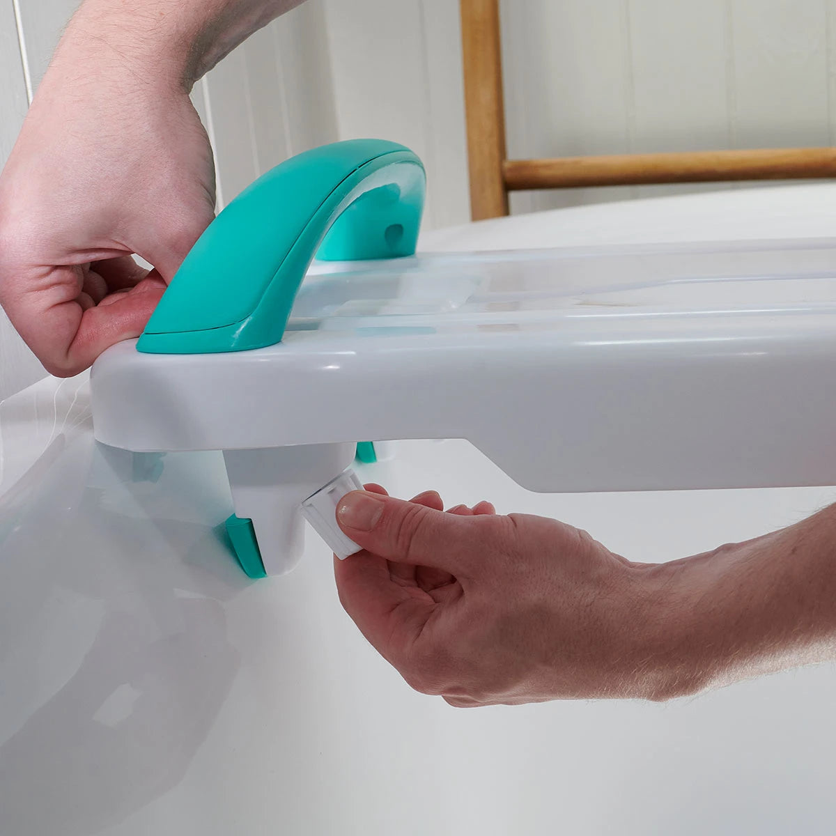 A person adjusting a bath support device with a handle
