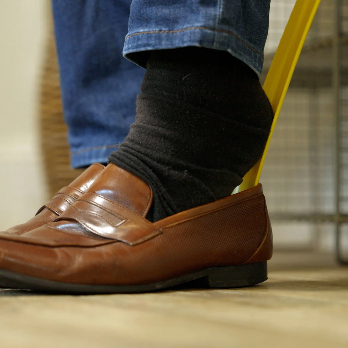 A person using a shoe horn to put on their shoes