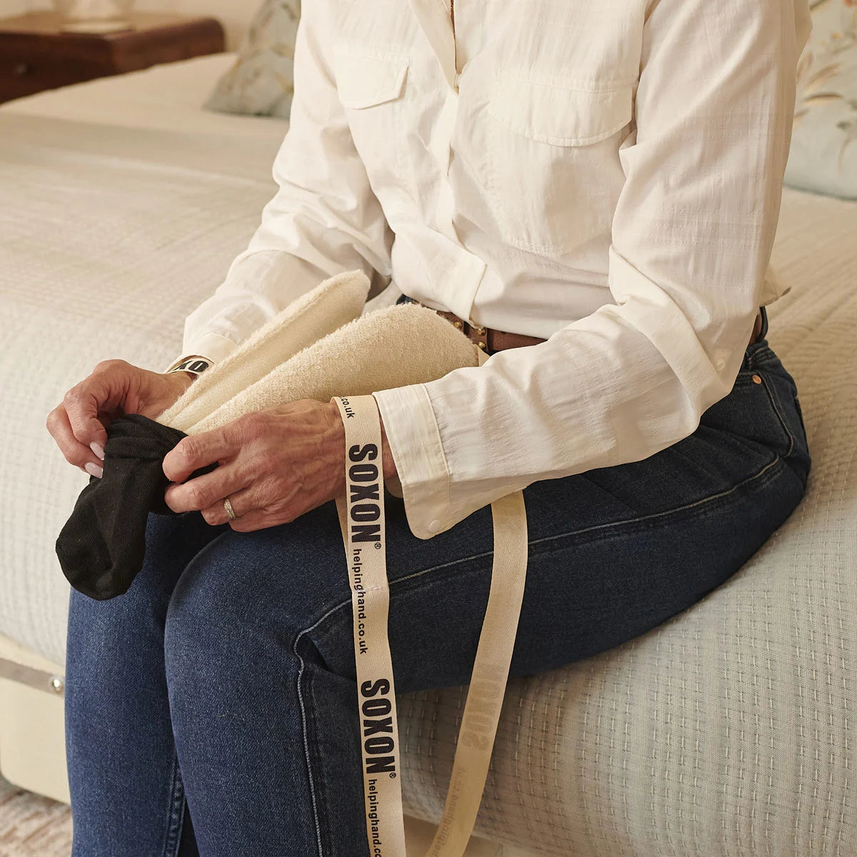 A person putting socks onto a sock aid