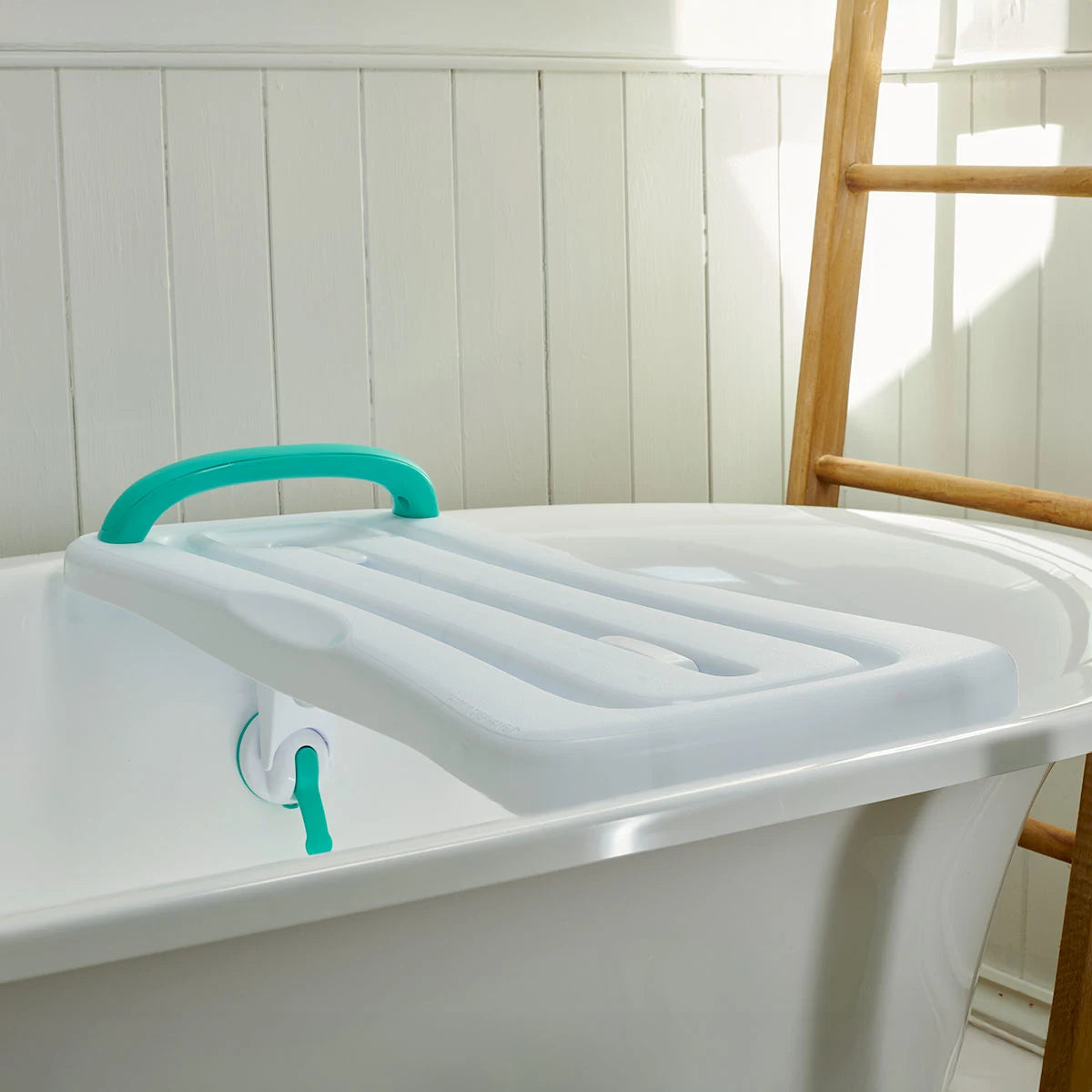 White bathtub with a green handle and support device in a bathroom setting.