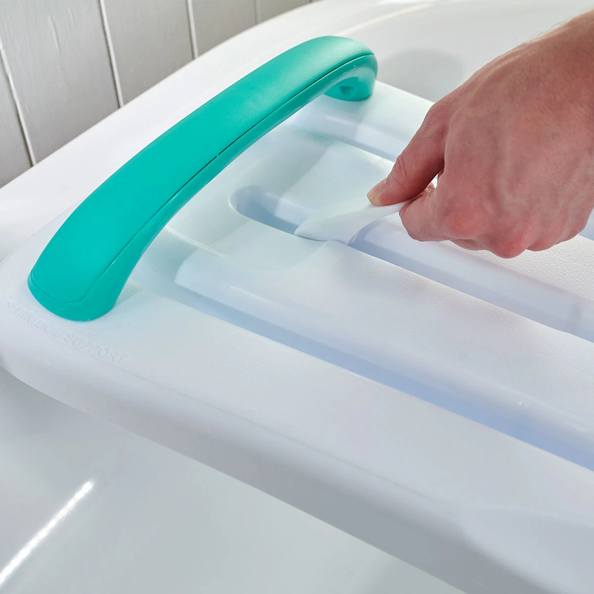 Person using a bath shoer board with a turquoise handle