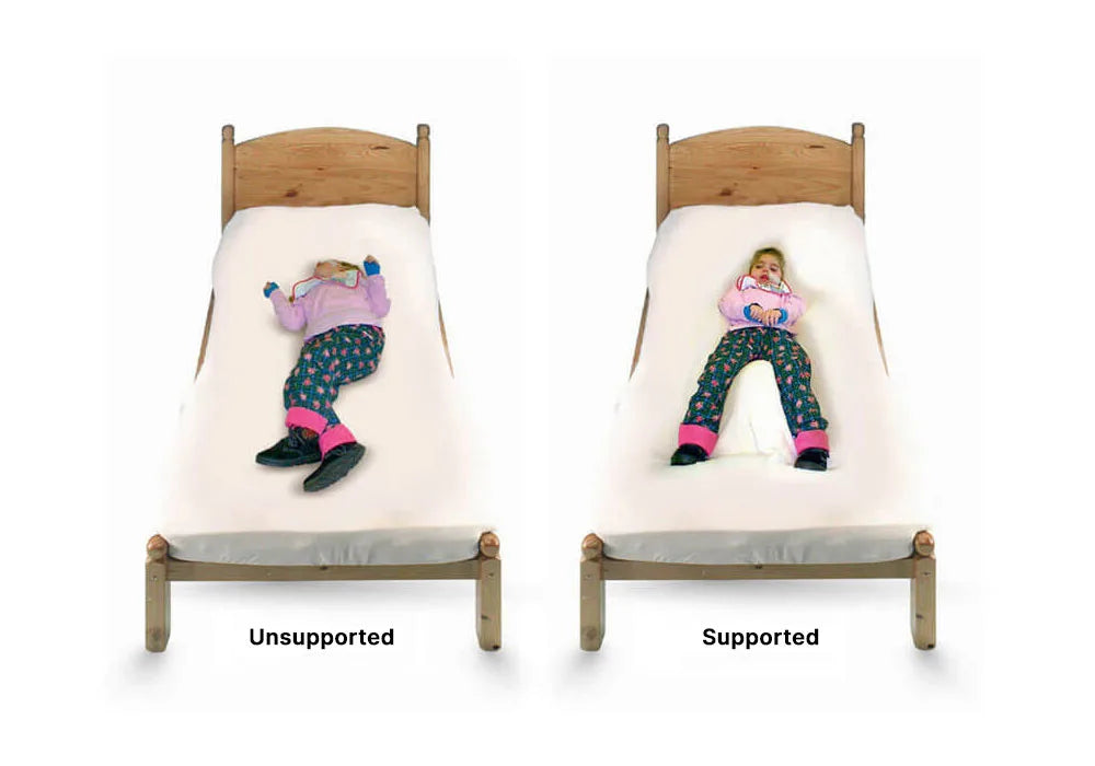 A child relaxing on a bed with supportive pillows