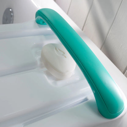 Teal handle on a white bathtub with a white soap bar.