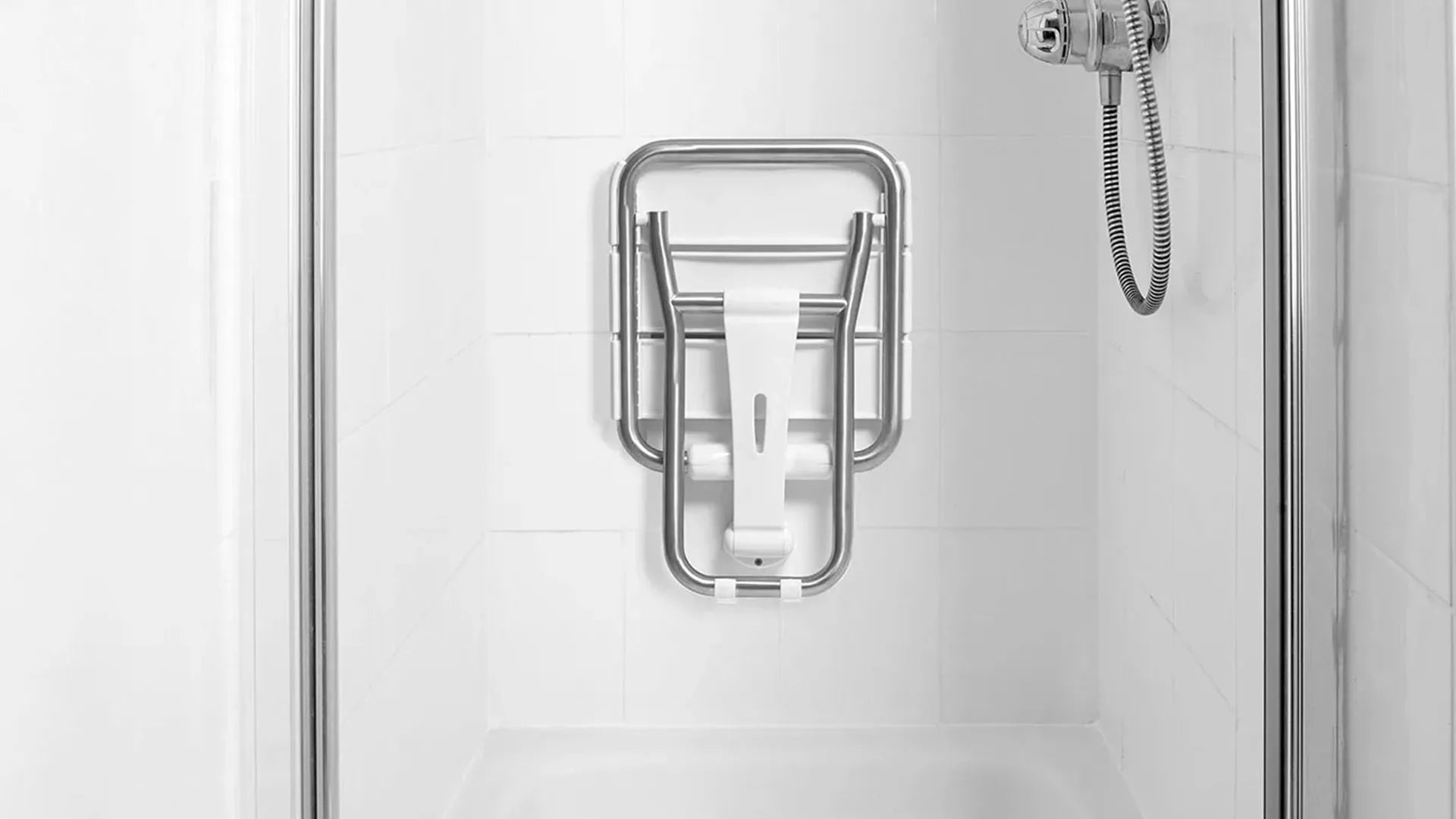 Shower enclosure with a shower seat on a white tiled wall.