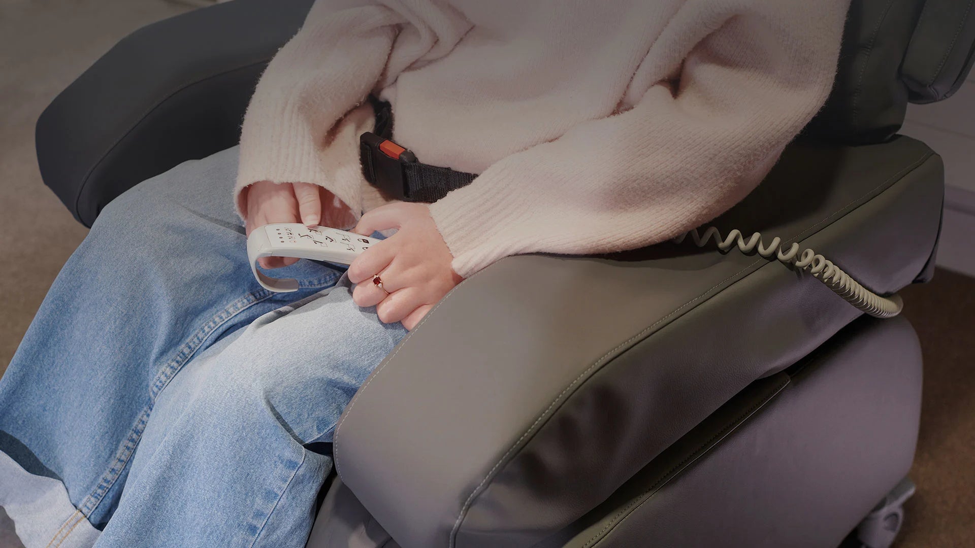 A woman holding a remote to a reclining chair